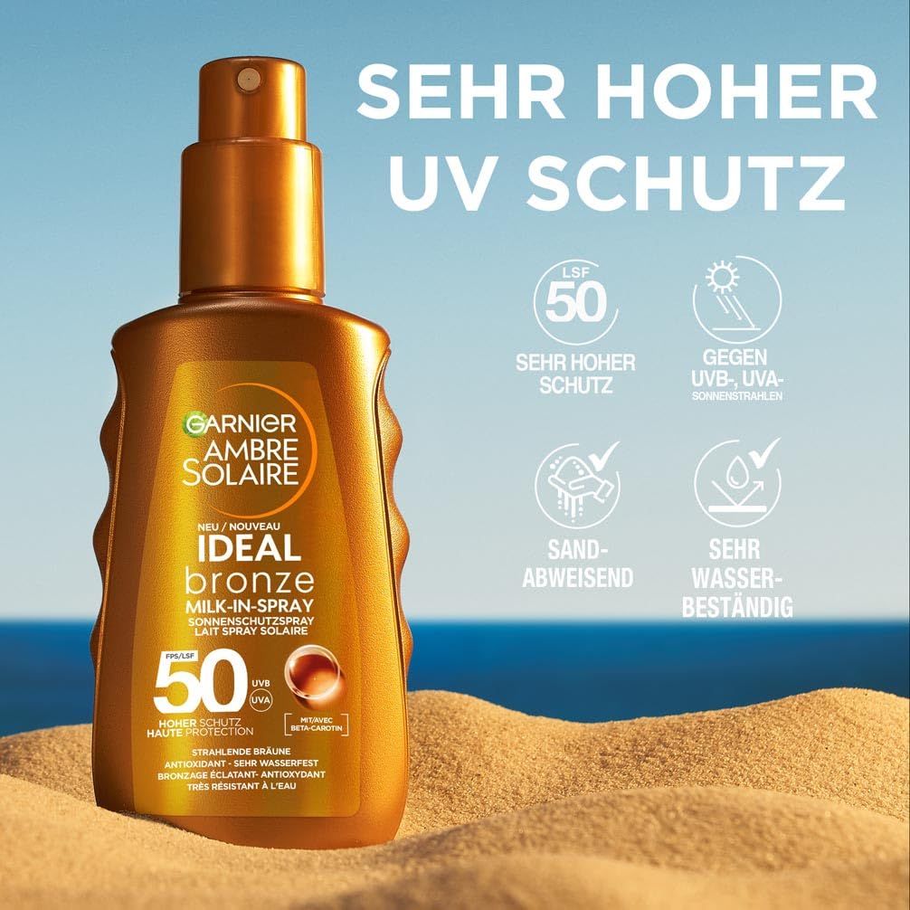 Garnier Ambre Solaire Ideal Bronze Milk-in-Spray 50. Flasche auf Sand. Text: Sehr hoher UV-Schutz, LSF 50, sandabweisend, wasserfest.
