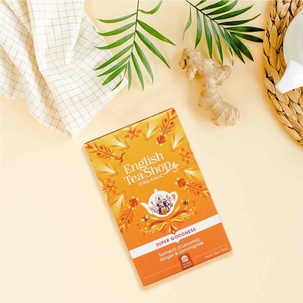 Theebox mit Kurkuma, Ingwer und Zitronengras. Daneben Ingwer und Blätter. English Tea Shop Organic.