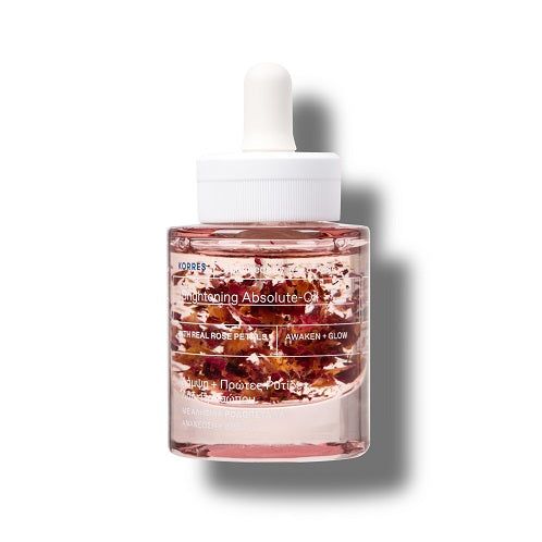 Gesichtsöl-Flakon mit Pipette. Rosa Flüssigkeit mit Blütenblättern. Weißer Deckel mit Aufschrift KORRES.