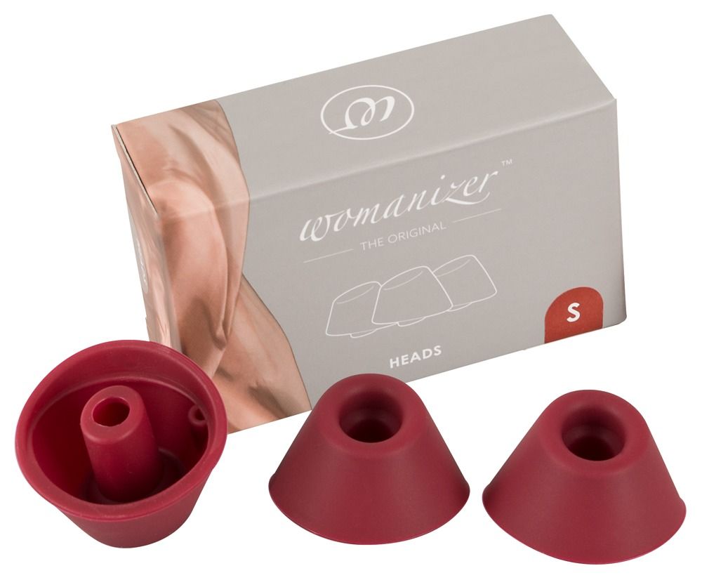 Drei rote Ersatzkappen und eine Verpackung mit "Womanizer"-Schriftzug und "HEADS".