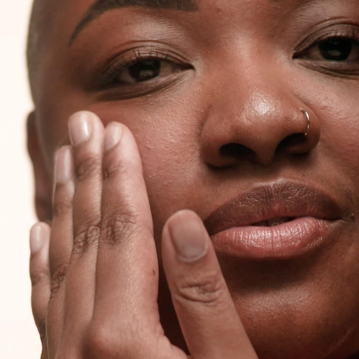 Nahaufnahme einer Person, die ihr Gesicht berührt.