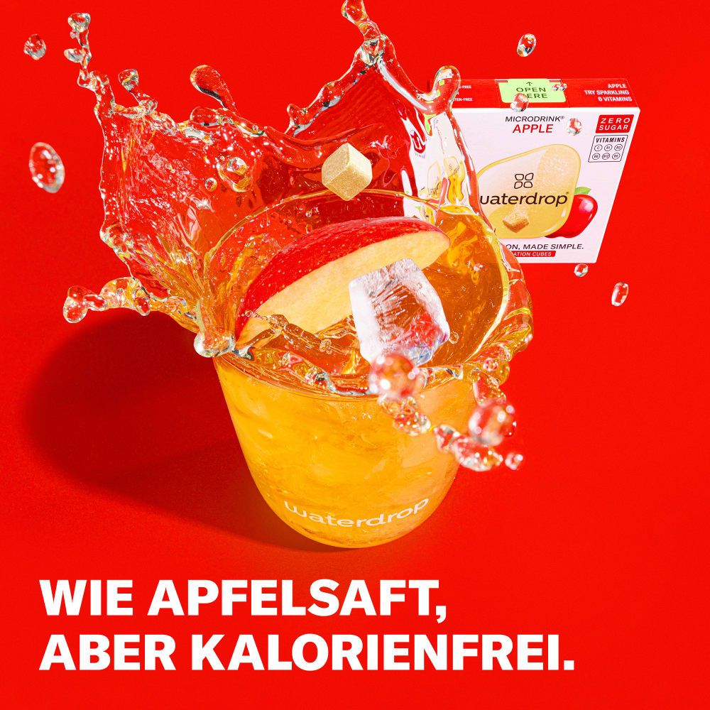 Glas mit Wasser und Eiswürfeln, darin ein waterdrop® Würfel. Aufschrift: waterdrop®. Auf rotem Hintergrund, mit Apfel-Motiven.