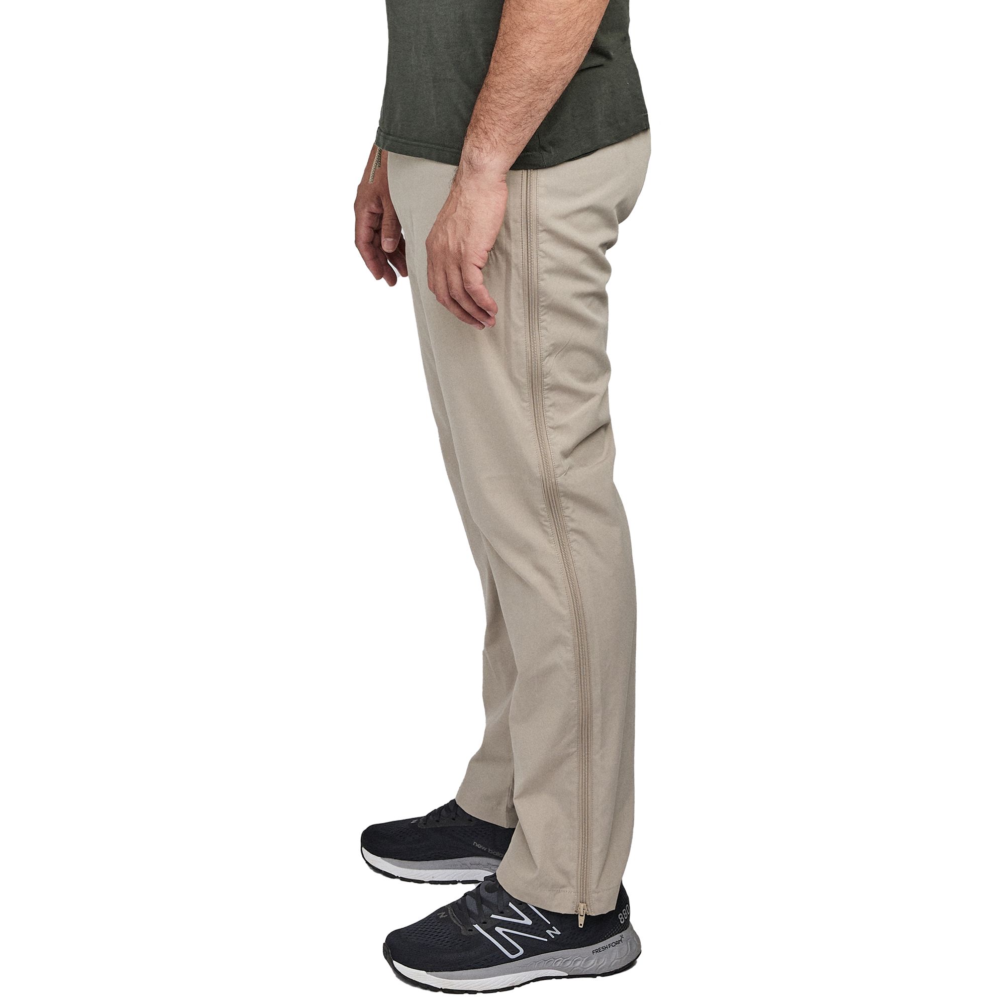 Beige Sporthose mit seitlichem Reißverschluss. Seitenansicht. Gerade geschnitten, mit Reißverschluss am Bein. Mann trägt die Hose.