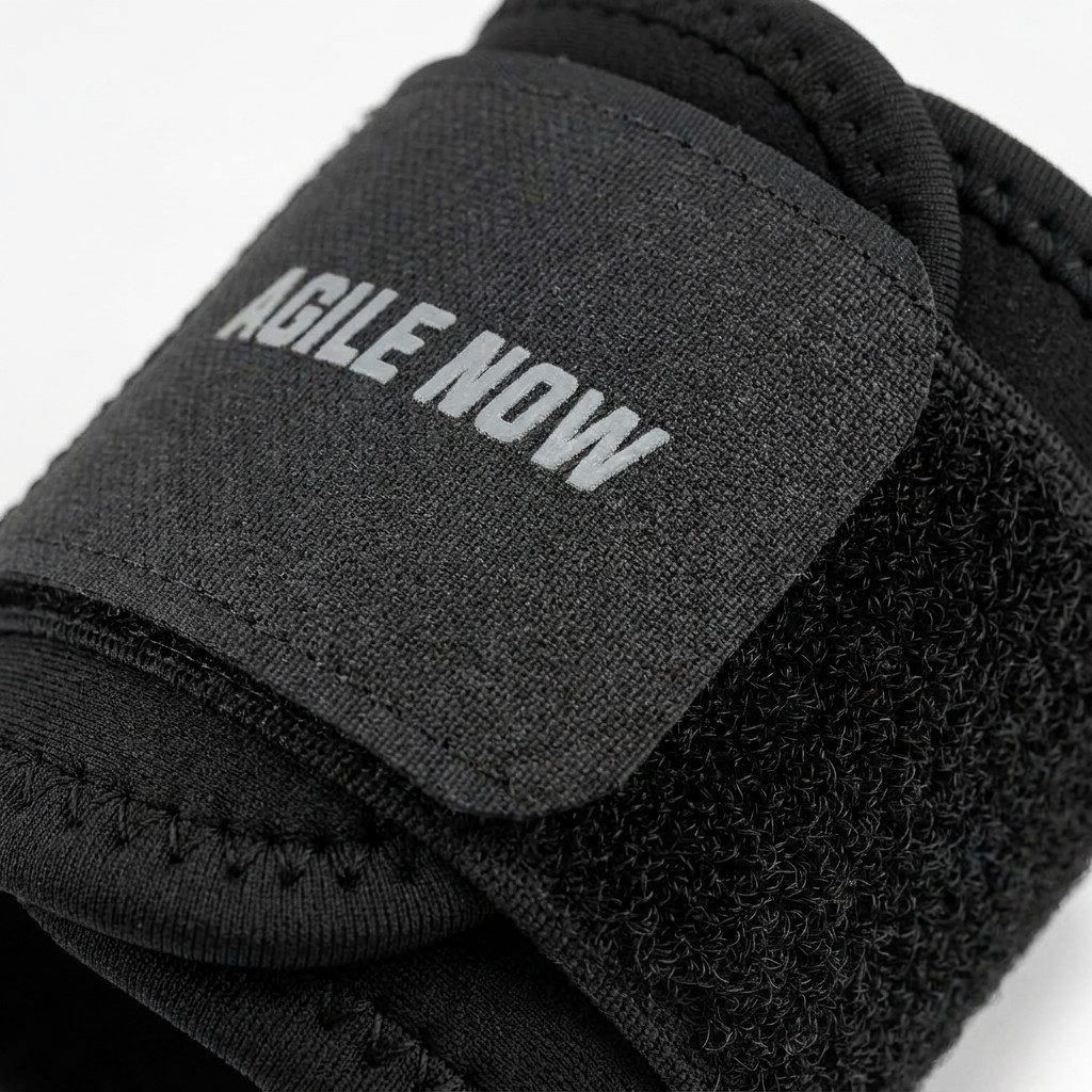 Schwarze Handgelenkbandage mit Klettverschluss und dem Aufdruck "AGILE NOW".