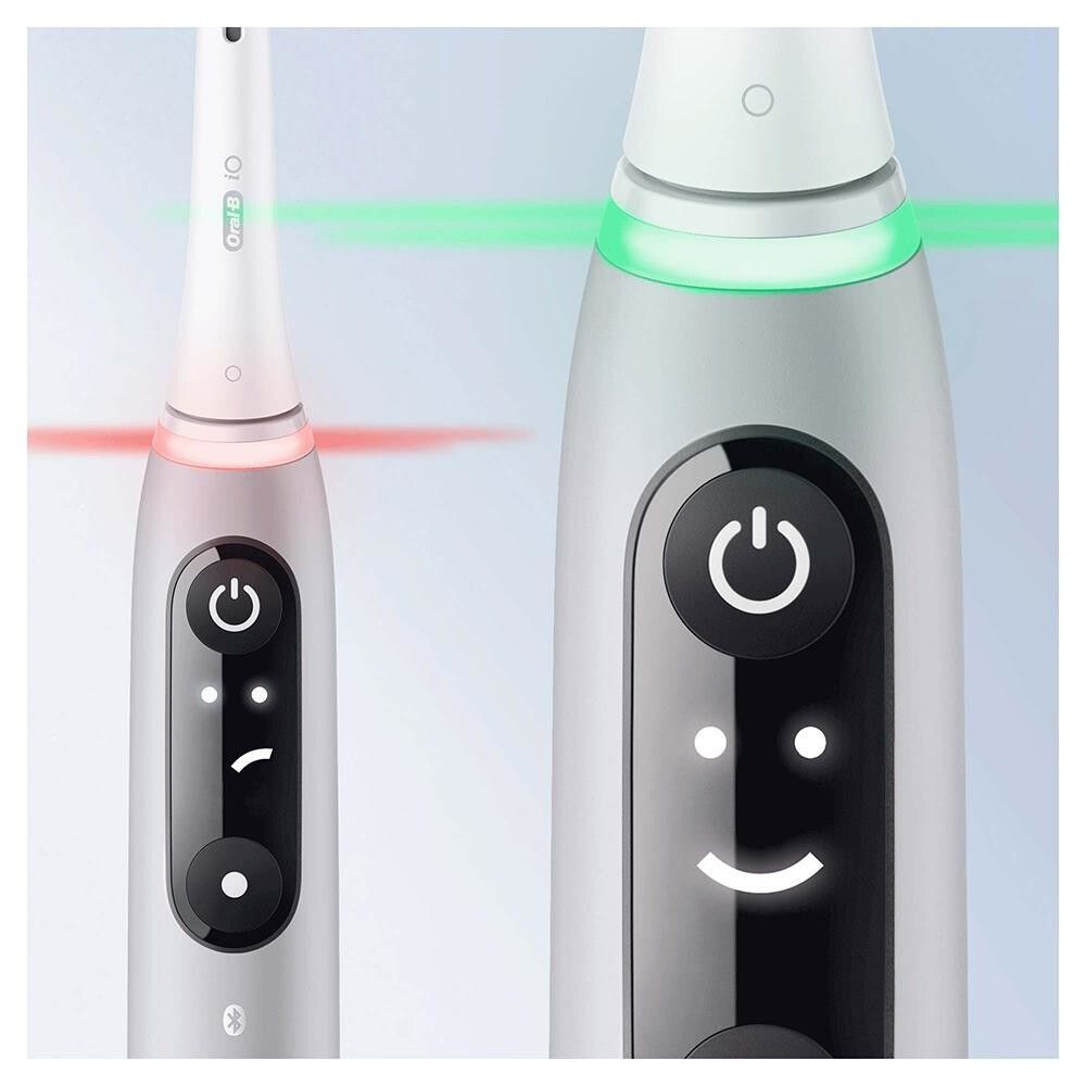 Nahaufnahme von zwei Zahnbürsten. Anzeige mit Smileys und farbigen Lichtsignalen. Schwarze und graue Elemente.
