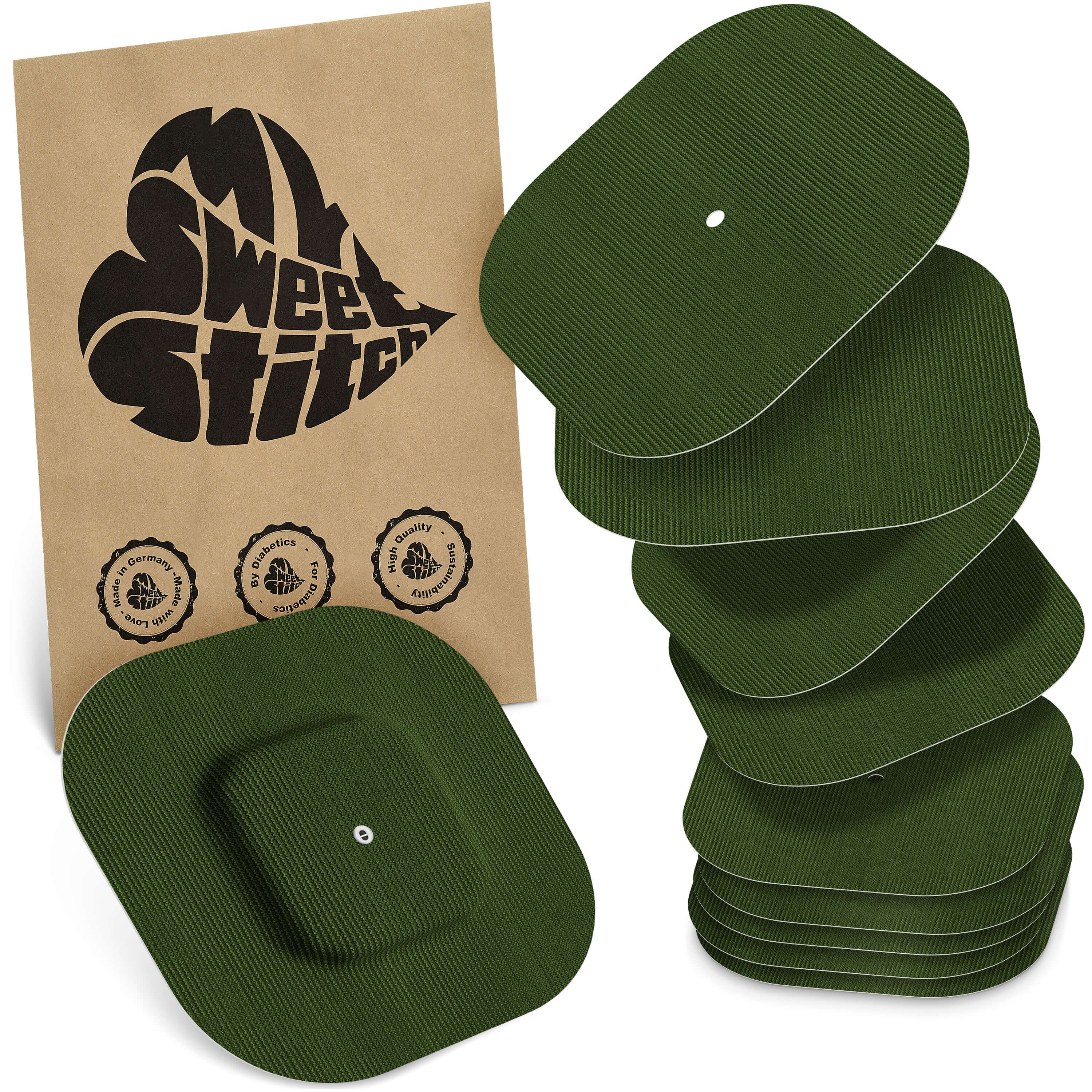 Grüne, rechteckige Pflaster mit abgerundeten Ecken. Einige sind gestapelt, andere liegen daneben. Eine Packung mit Logo ist im Hintergrund.