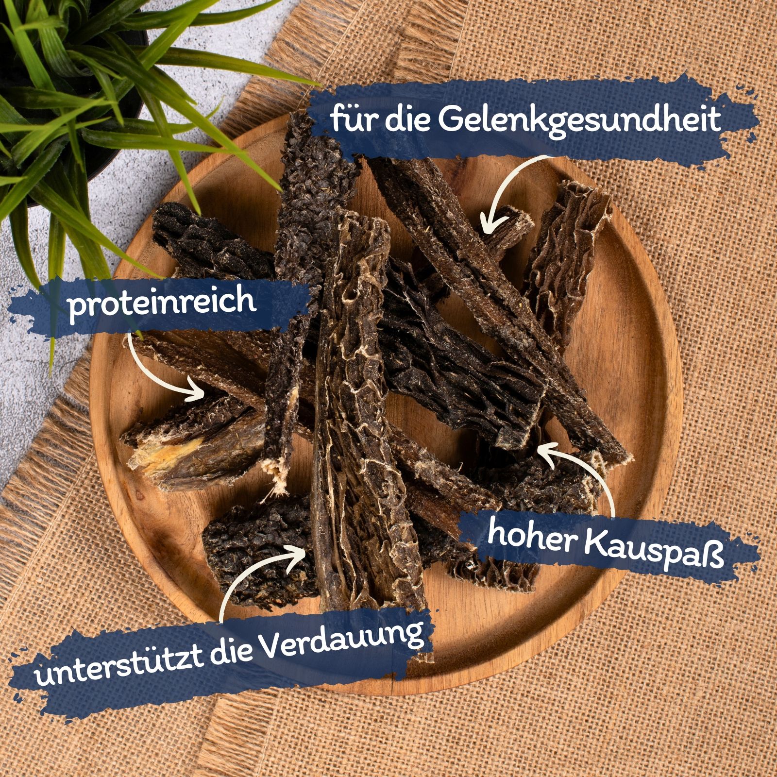 Getrocknete Rinderkopfhaut-Streifen auf einem Holzteller mit Beschriftungen.