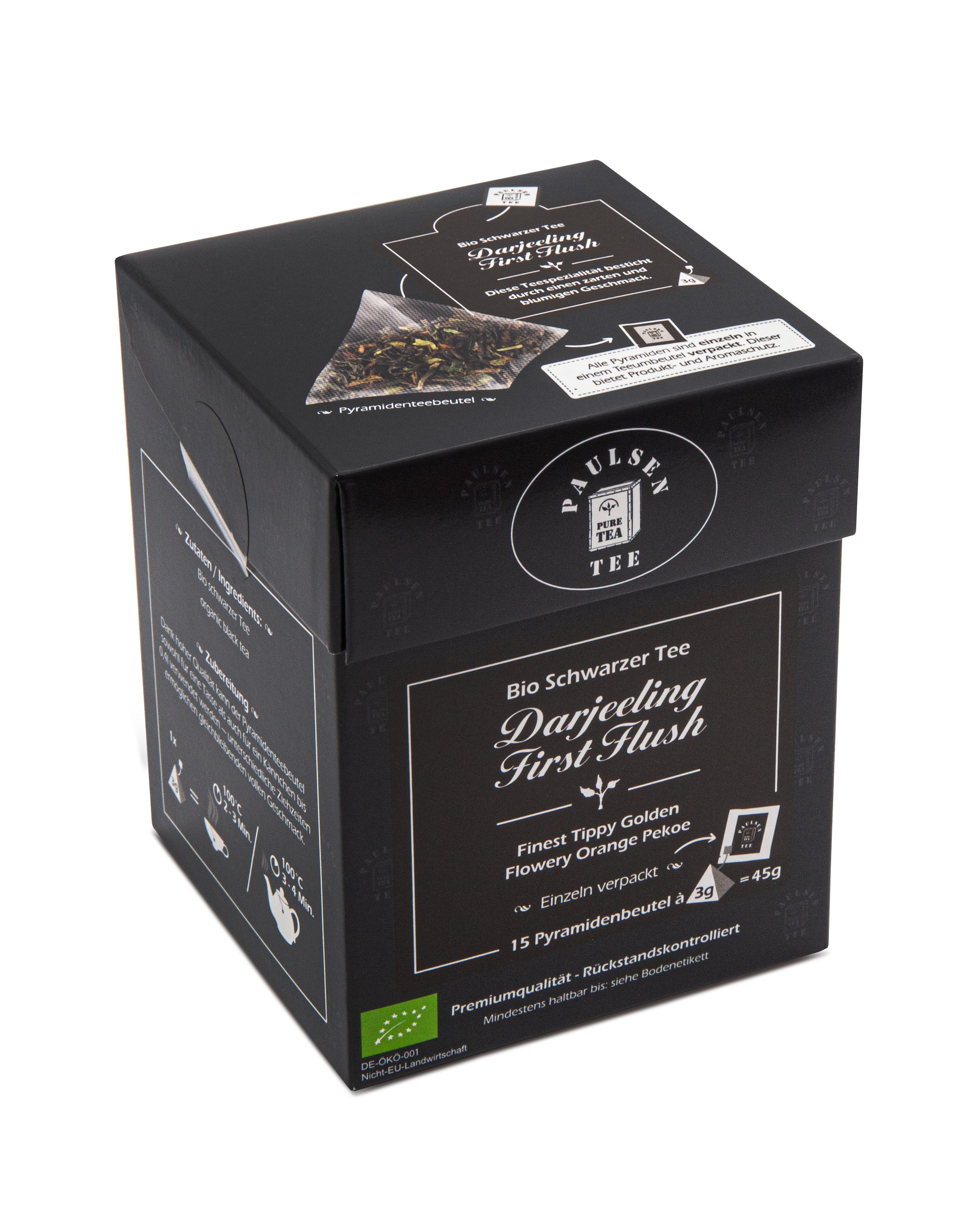 Schwarzer Tee-Box mit Aufschrift 'Darjeeling First Flush'. Schwarze Box mit Logo und Produktinformationen. Pyramidenbeutel-Abbildung.