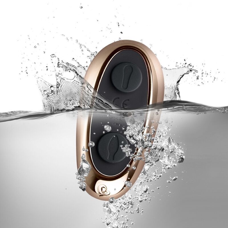 Goldfarbene Fernbedienung im Wasser. Mit zwei Knöpfen und CE-Kennzeichnung. Wasserspritzer.