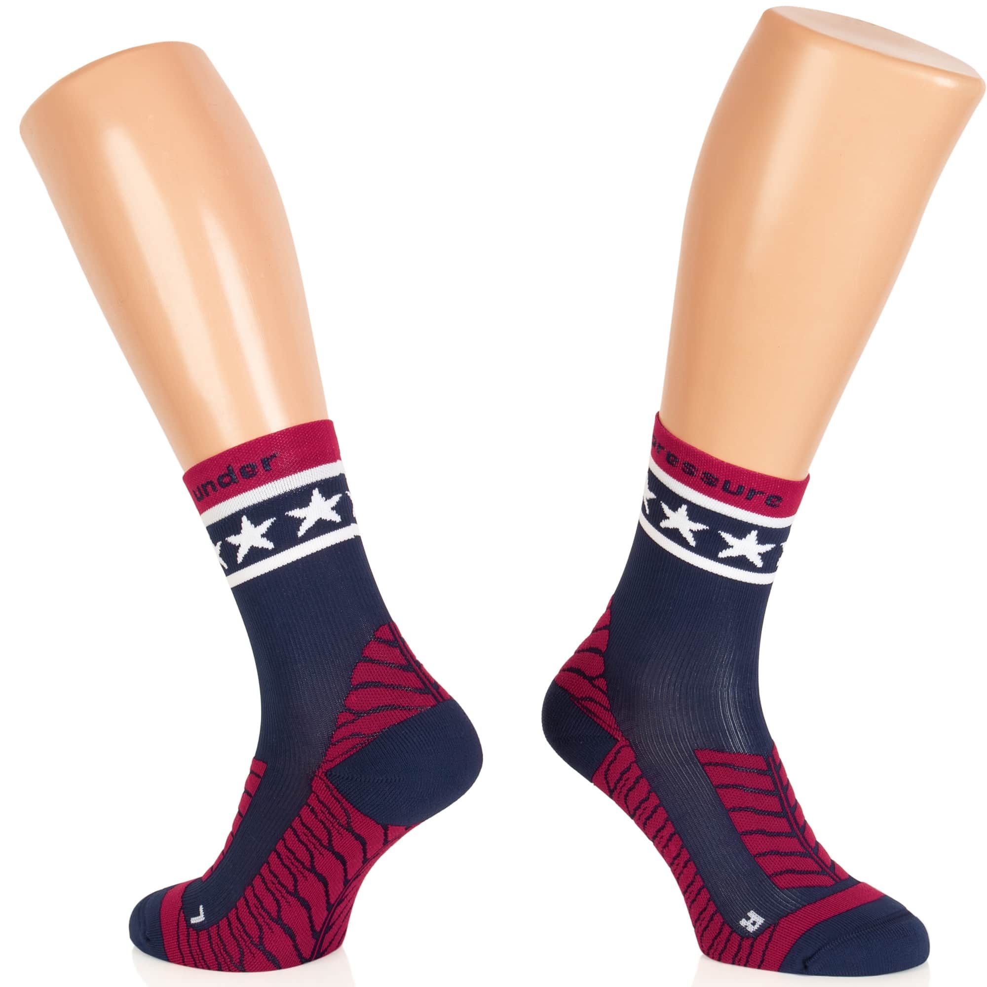 Socken auf Schaufensterpuppen. Dunkelblau mit rotem Bund und Sternen. Rote Muster an Ferse und Fußrücken. Aufschrift: Pressure.