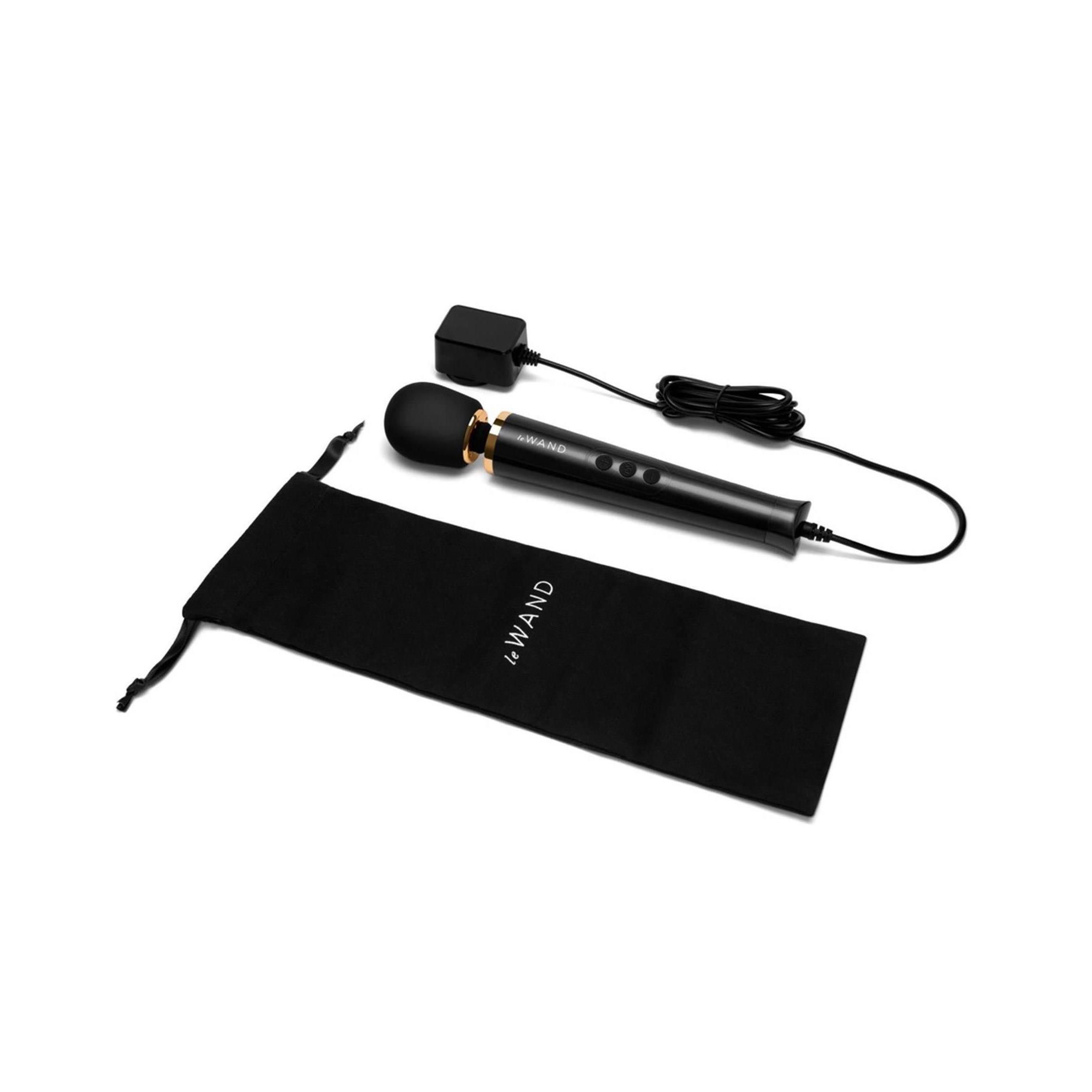 Schwarzer Massagestab, Netzteil und Beutel. Goldfarbene Akzente, drei Knöpfe. Aufschrift: le Wand.