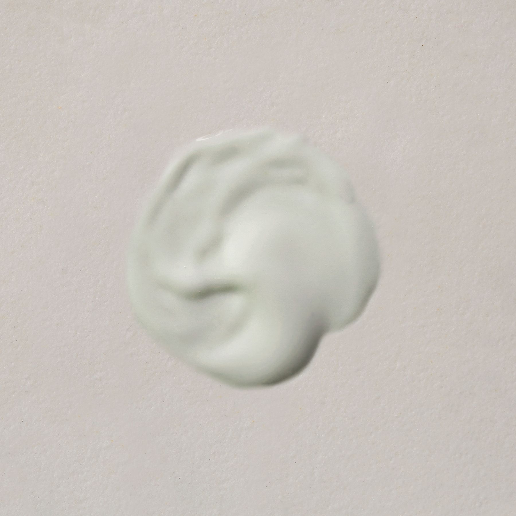 Ein Klecks hellgrüner Gesichtsmaske auf hellem Hintergrund.