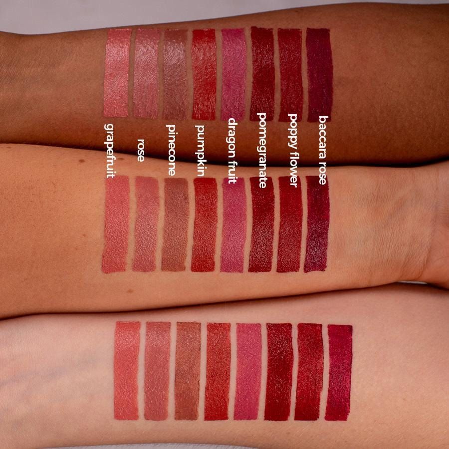 Arme mit Lippenstift-Swatches in verschiedenen Rottönen. Namen: Grapefruit, Rose, Pinecone, Pumpkin, Dragon Fruit, Pomegranate, Poppy Flower, Baccara Rose.