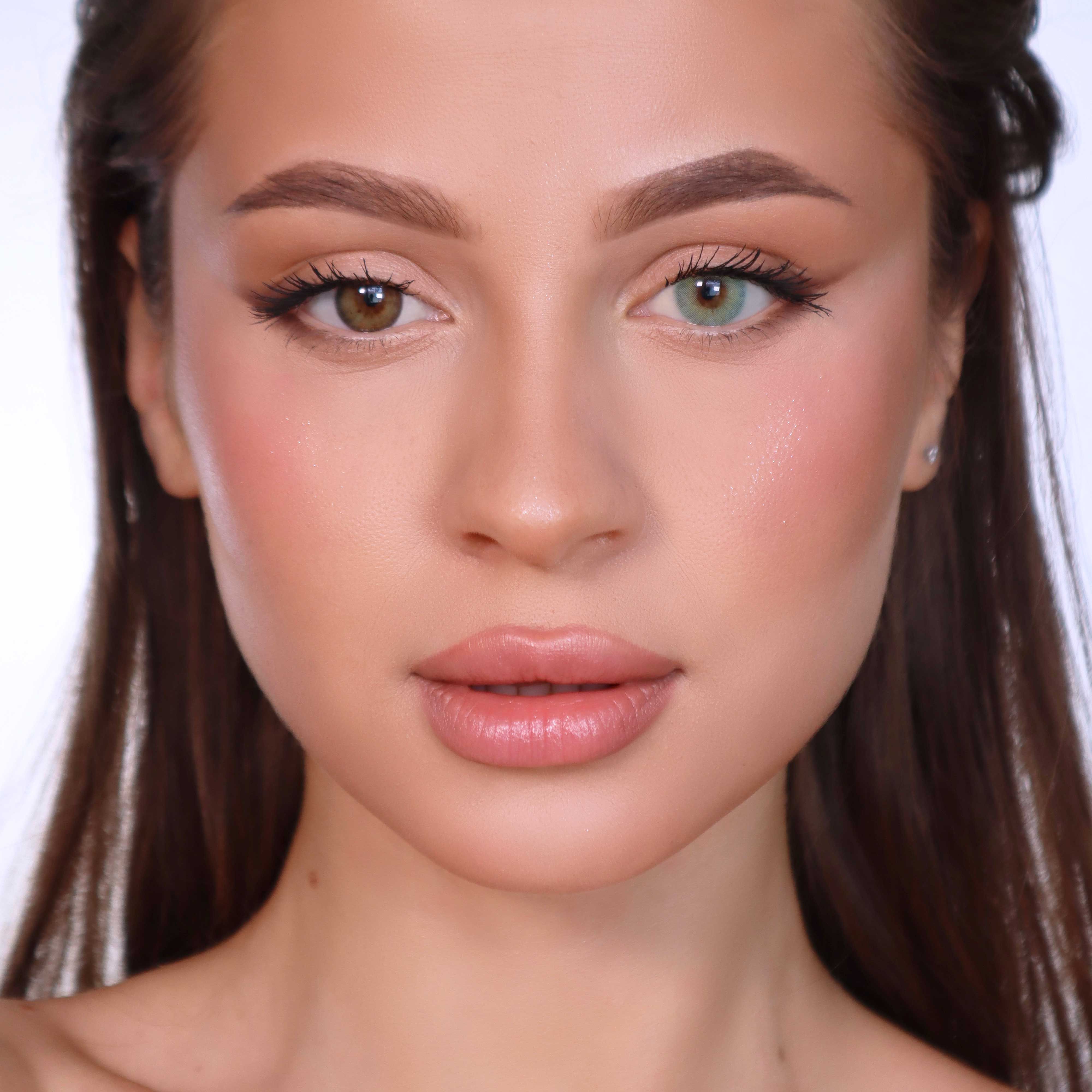 Porträt einer Frau mit zwei verschiedenfarbigen Augen. Ein Auge braun, das andere grün. Natürliches Make-up.