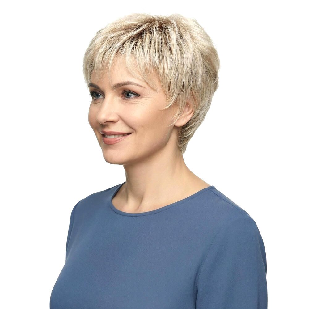 Seitenansicht einer Frau mit blondierter Kurzhaarperücke. Die Perücke hat einen kurzen, gestuften Schnitt. Die Frau trägt ein blaues Oberteil.