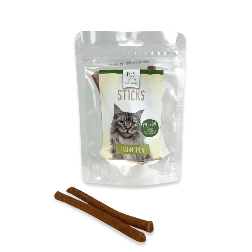 Verpackung mit Sticks für Katzen. Aufdruck mit Katze und Schriftzug. Zwei braune Sticks liegen davor.