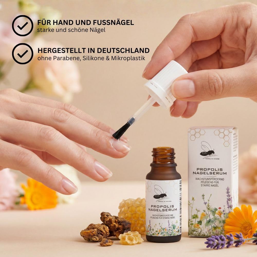 Hand wendet Propolis Nagelserum mit Pinsel an. Flasche und Schachtel im Hintergrund.