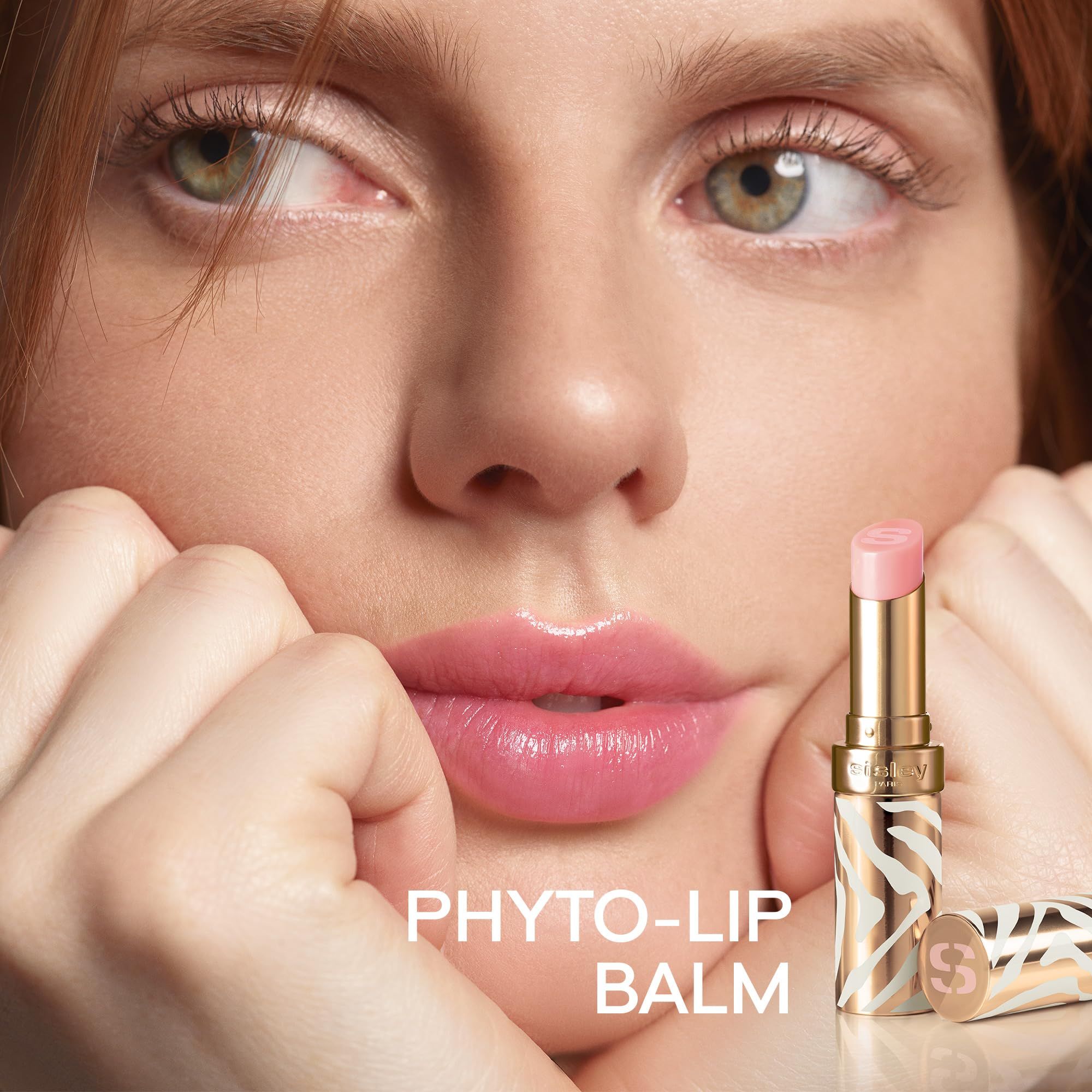Frau mit Lippenbalsam. Produktname: PHYTO-LIP BALM. Goldfarbenes Gehäuse mit Zebra-Muster.