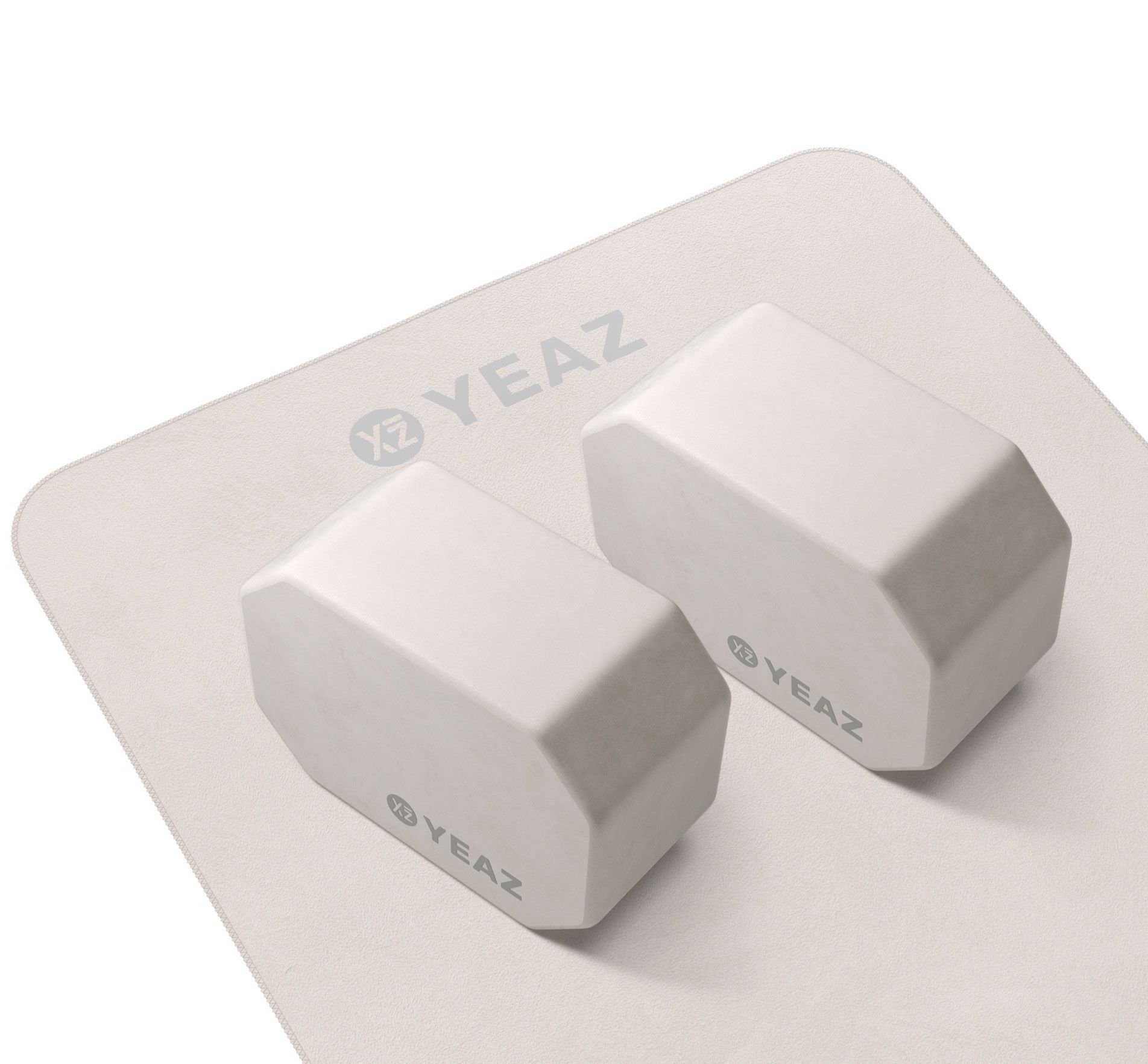 Zwei weiße Yoga-Blöcke auf einer weißen Matte. Das Logo YEAZ ist auf beiden Produkten sichtbar.