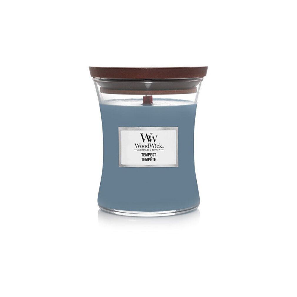 Hourglass-Kerze mit Holzdeckel. Blaues Wachs, rechteckiges Etikett mit Logo und Text. Holzdocht sichtbar.
