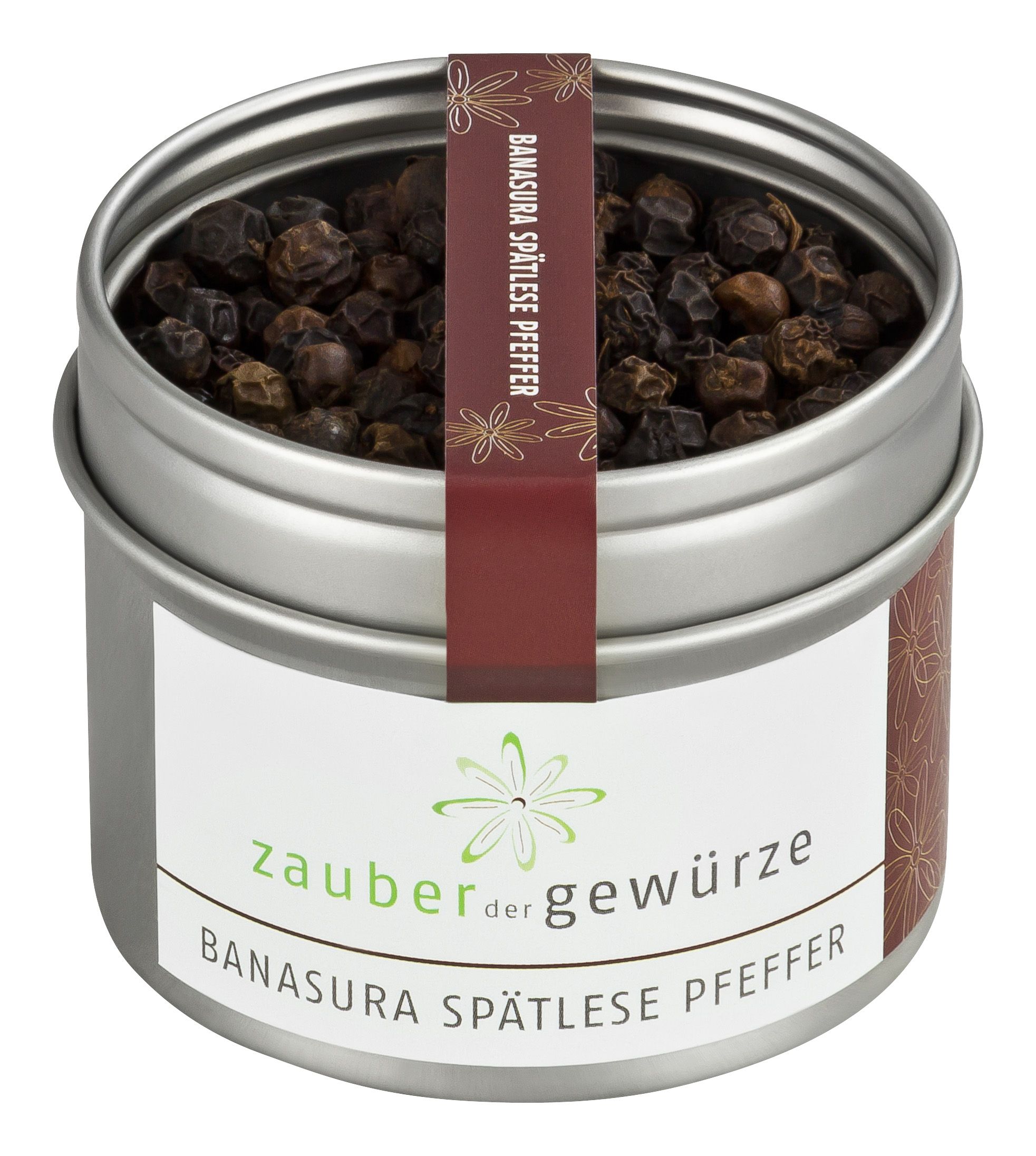 Runde Dose mit Pfefferkörnern. Aufschrift: Zauber der Gewürze, Banasura Spätlese Pfeffer. Etikett und Band mit floralem Muster.
