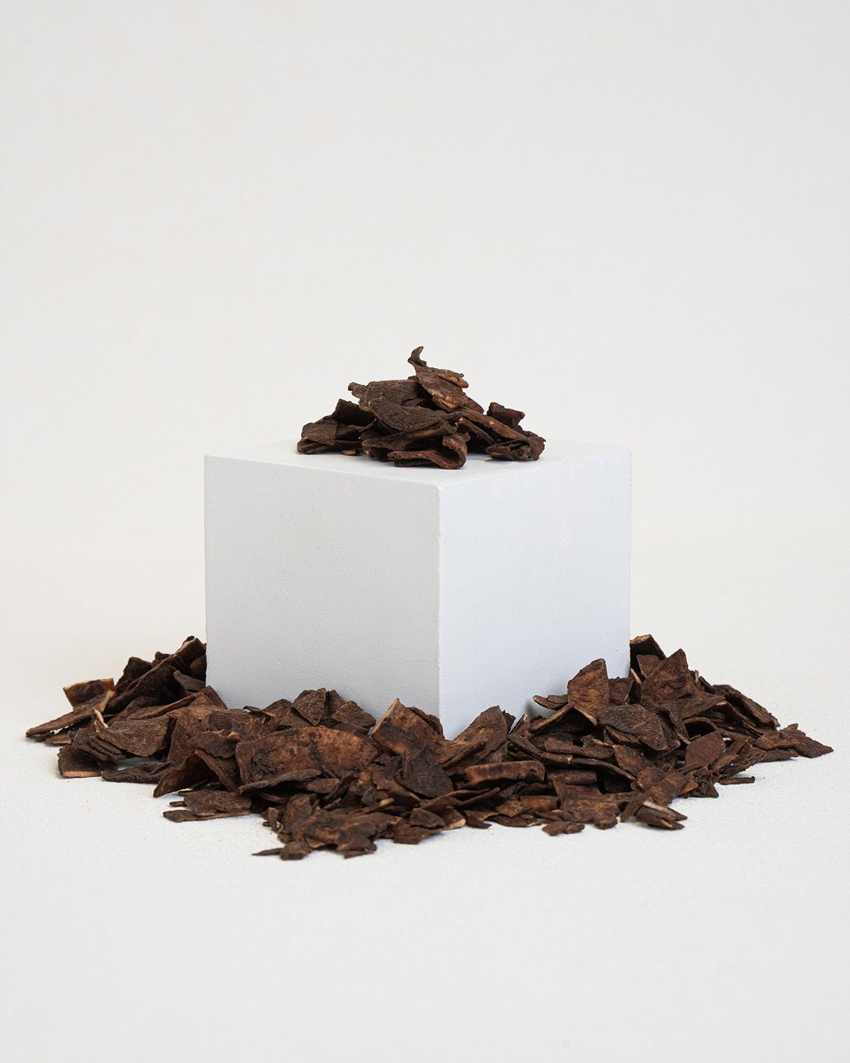 Haufen von Kokoschips auf einer weißen Box und daneben verstreut.
