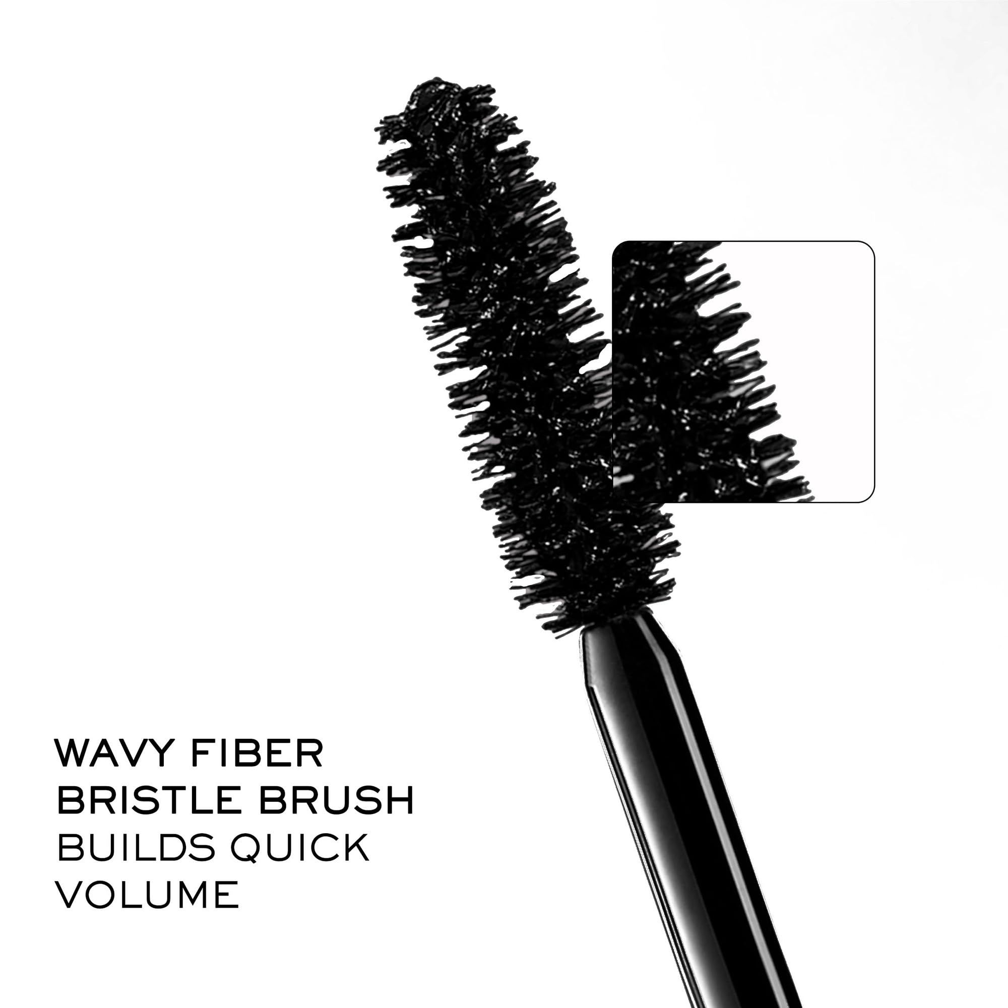 Nahaufnahme der Mascarabürste. Text: WAVY FIBER BRISTLE BRUSH BUILDS QUICK VOLUME.