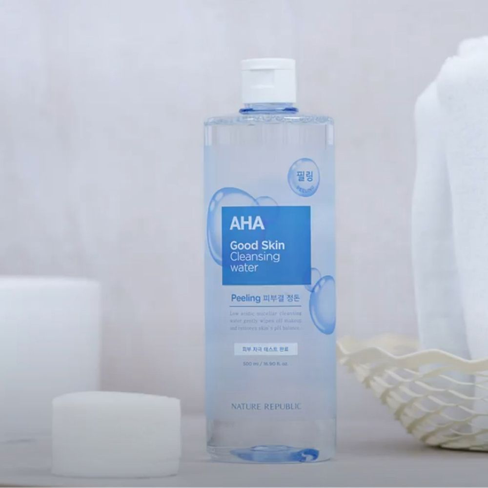 Klare Flasche mit blauem Etikett. Text: AHA Good Skin Cleansing Water. Marke: NATURE REPUBLIC. Koreanischer Text. Blauer Deckel. Hintergrund.