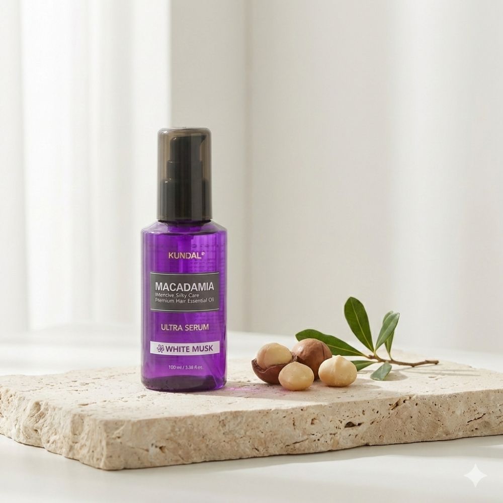KUNDAL Macadamia Ultra Haarserum in violetter Flasche auf Steinplatte mit Macadamianüssen.