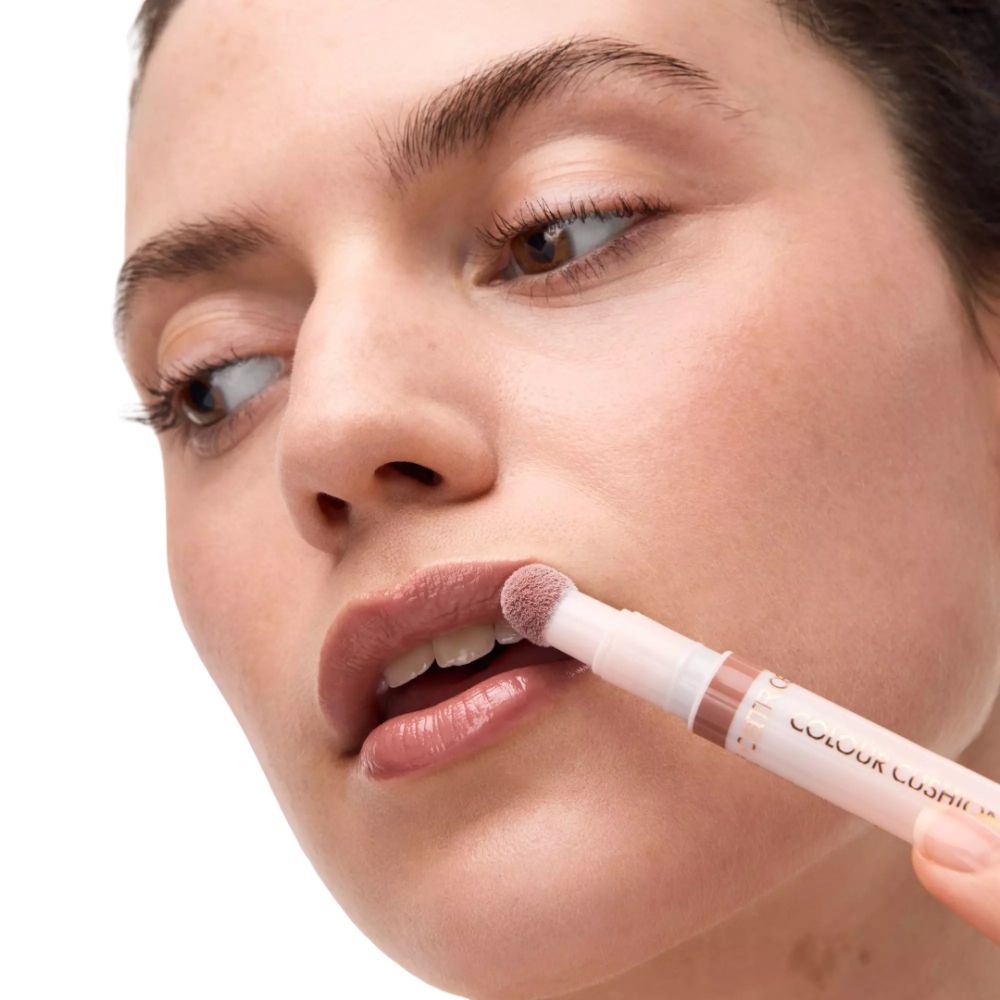 Person trägt Lippenöl auf. Der Applikator hat eine runde, weiße Spitze. Die Lippen sind glänzend.