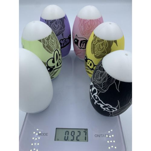 Sechs farbige Masturbatoren auf einer Waage. Verschiedene Farben und Designs. Gewicht: 0.927.