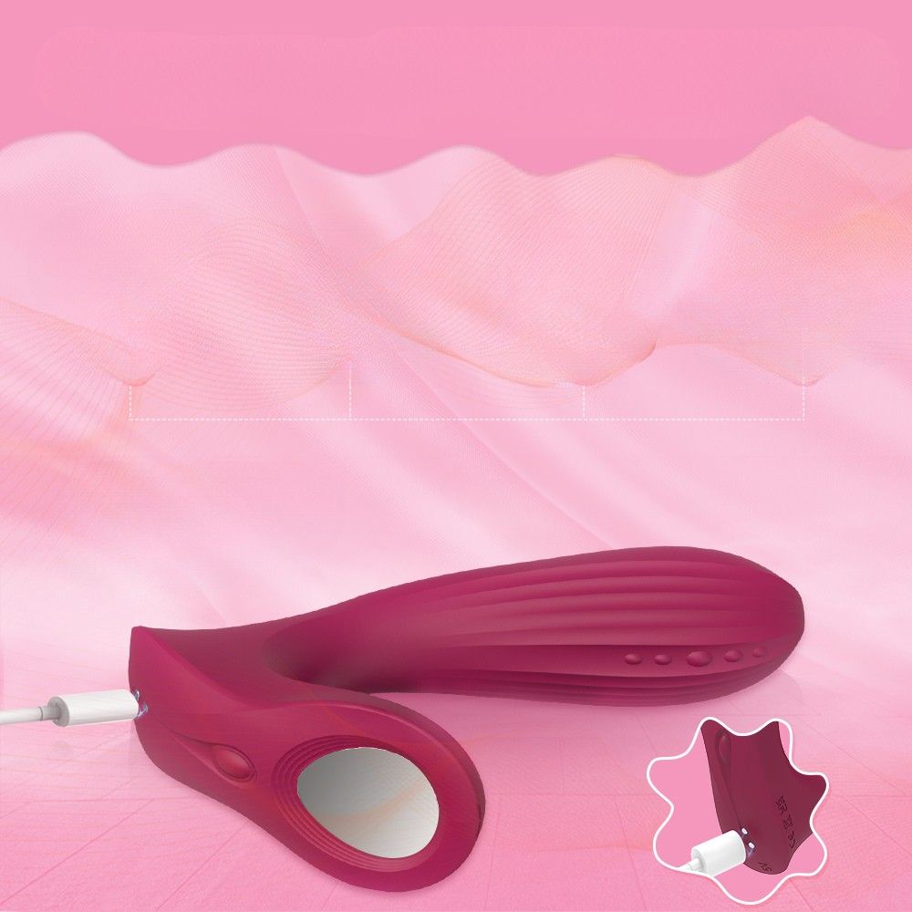 Weinroter Vibrator mit Ladekabel. Gebogene Form, Oberfläche mit Rillen. Ladeanschluss sichtbar.