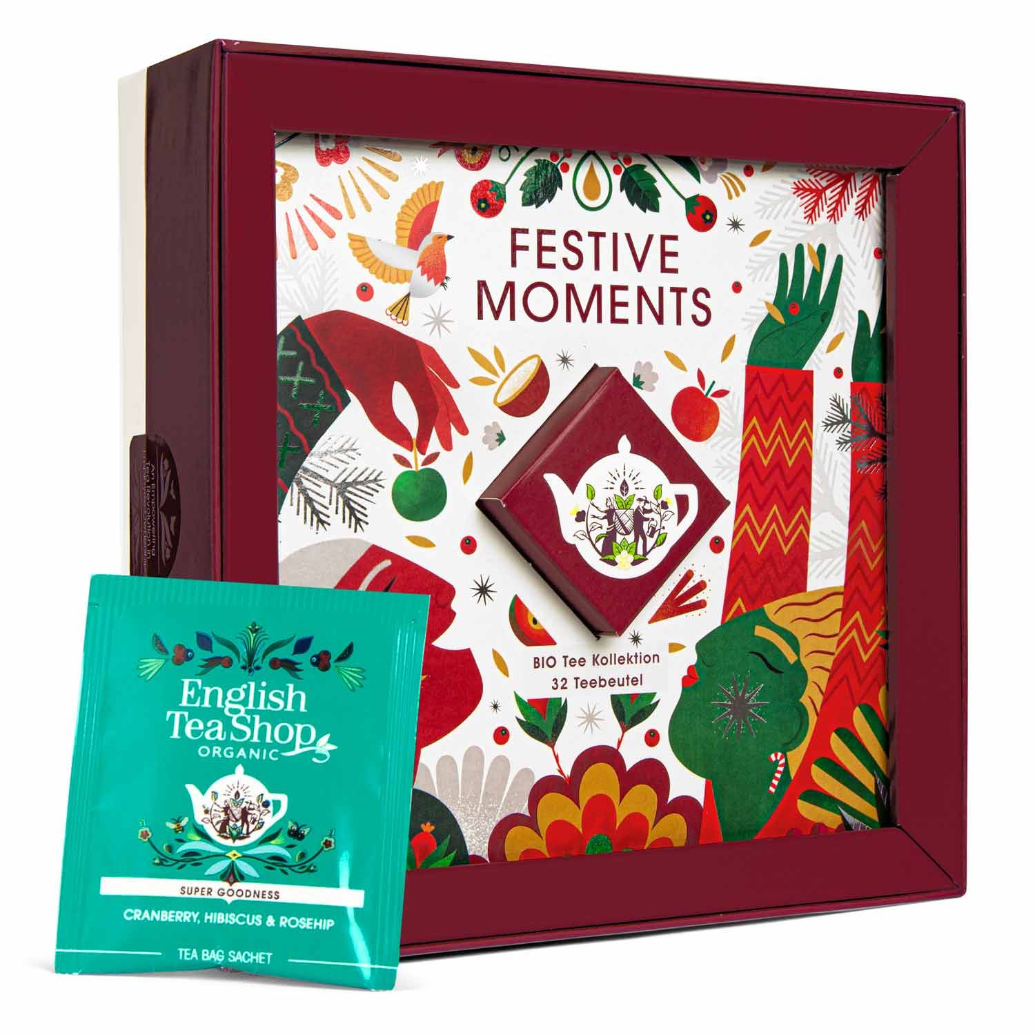 Geschenkbox mit Tee. Aufschrift "Festive Moments". BIO Tee Kollektion, 32 Teebeutel. Mit Teebeutel daneben.