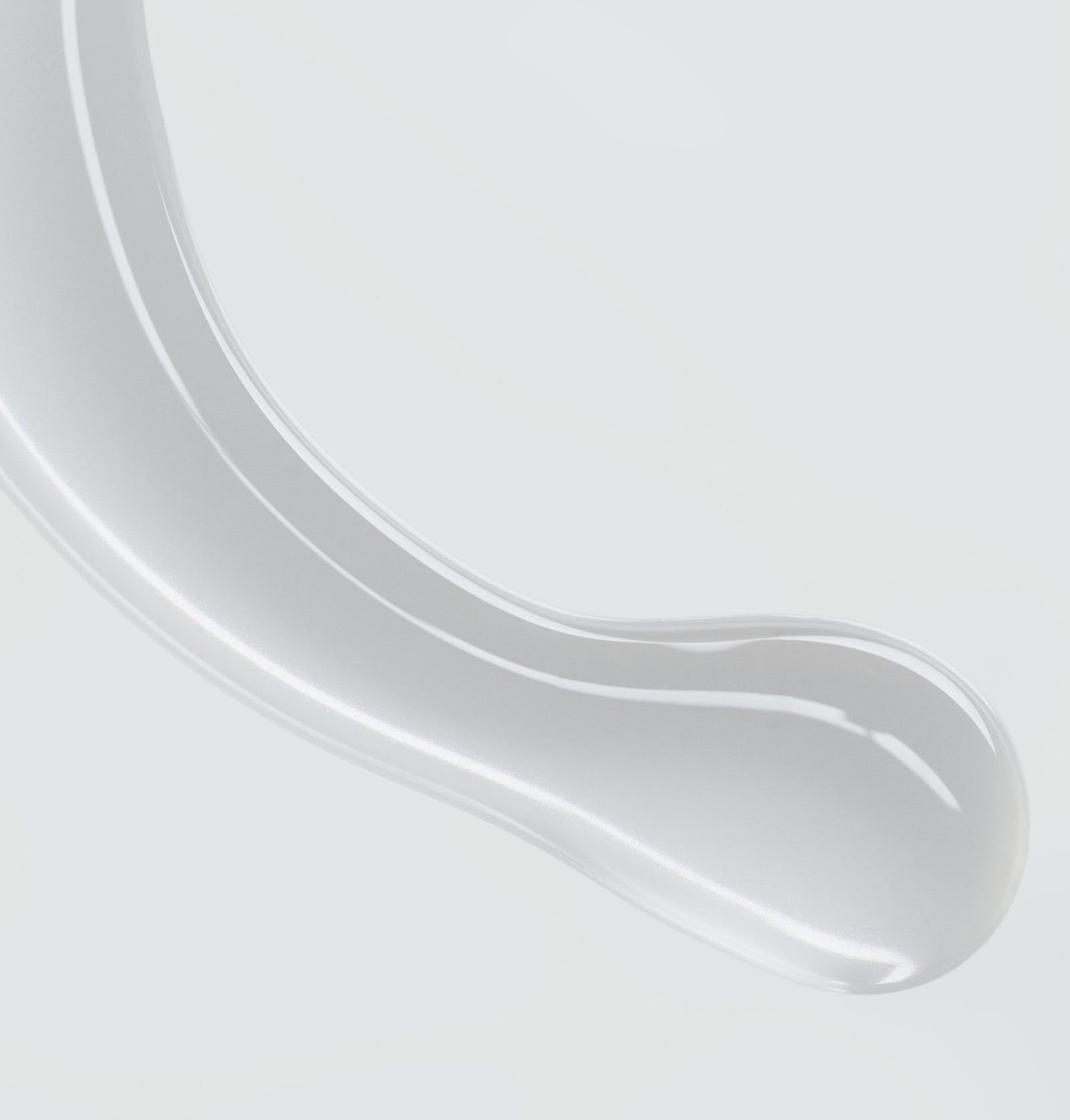 Nahaufnahme einer transparenten, gelartigen Substanz. Glänzende Oberfläche, geschwungene Form.