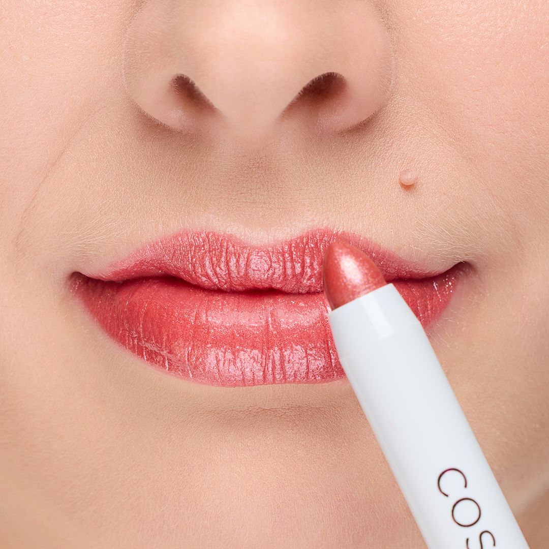 Lippenstift wird auf Lippen aufgetragen. Der Lippenstift ist weiß und trägt den Markennamen Cosline.