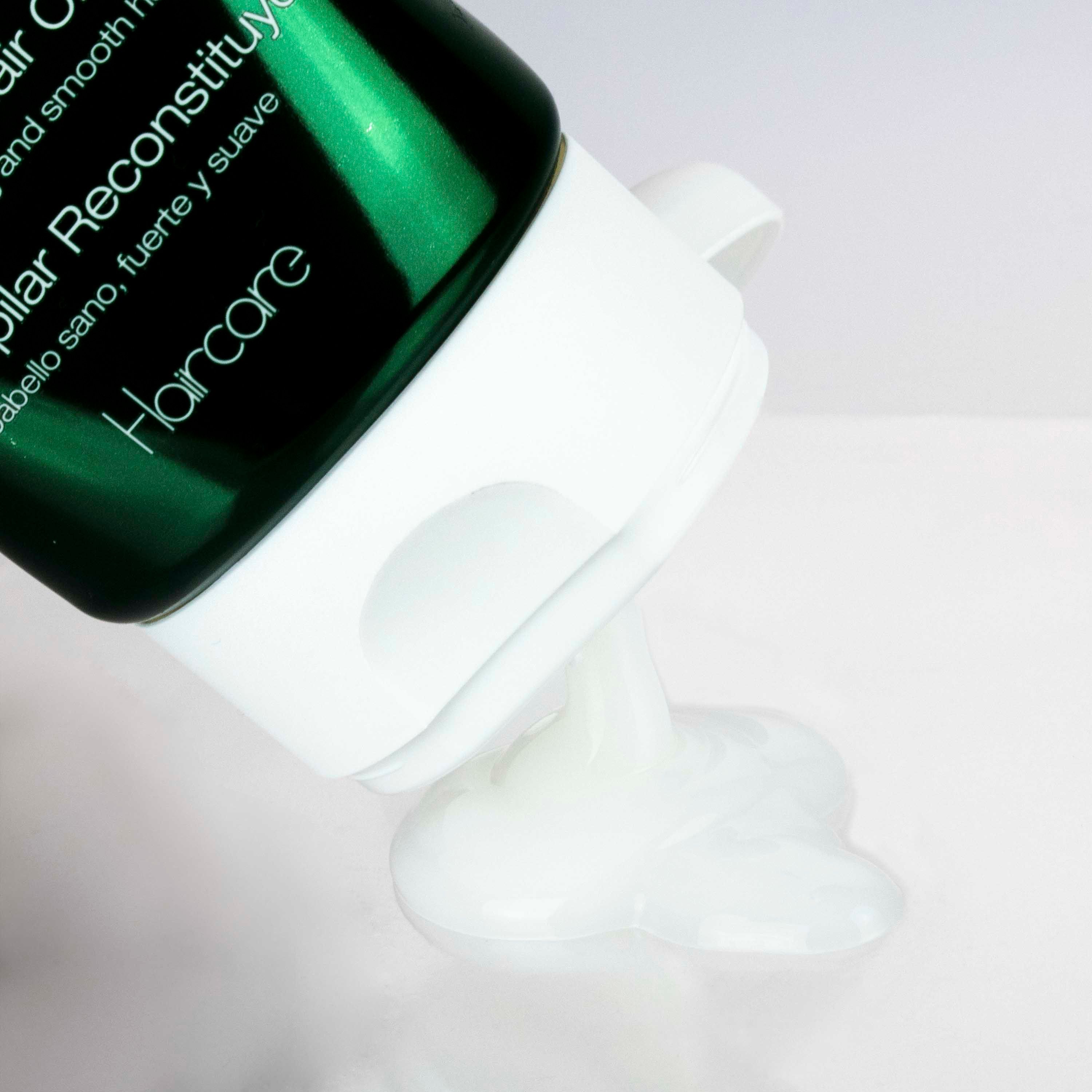 Produkt wird aus einer Tube gedrückt. Weiße, cremige Substanz. Hintergrund ist weiß.