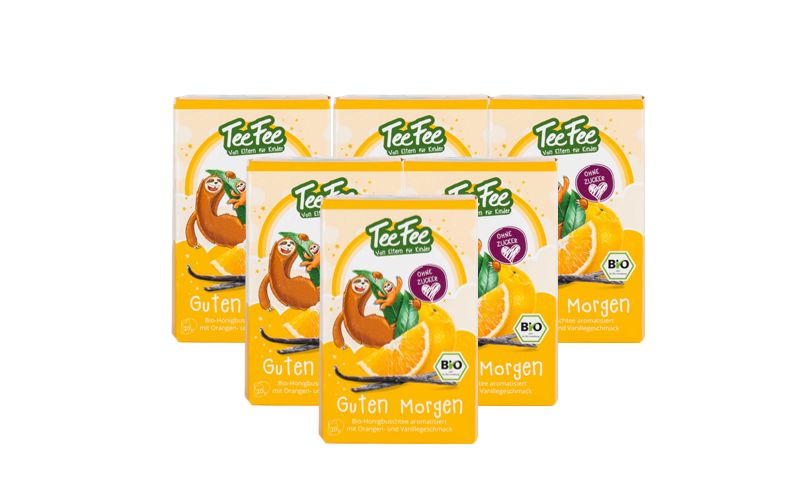 Mehrere Packungen TeeFee Guten Morgen Bio Kräutertee. Gelbe Verpackung mit Logo, Illustrationen und Text.