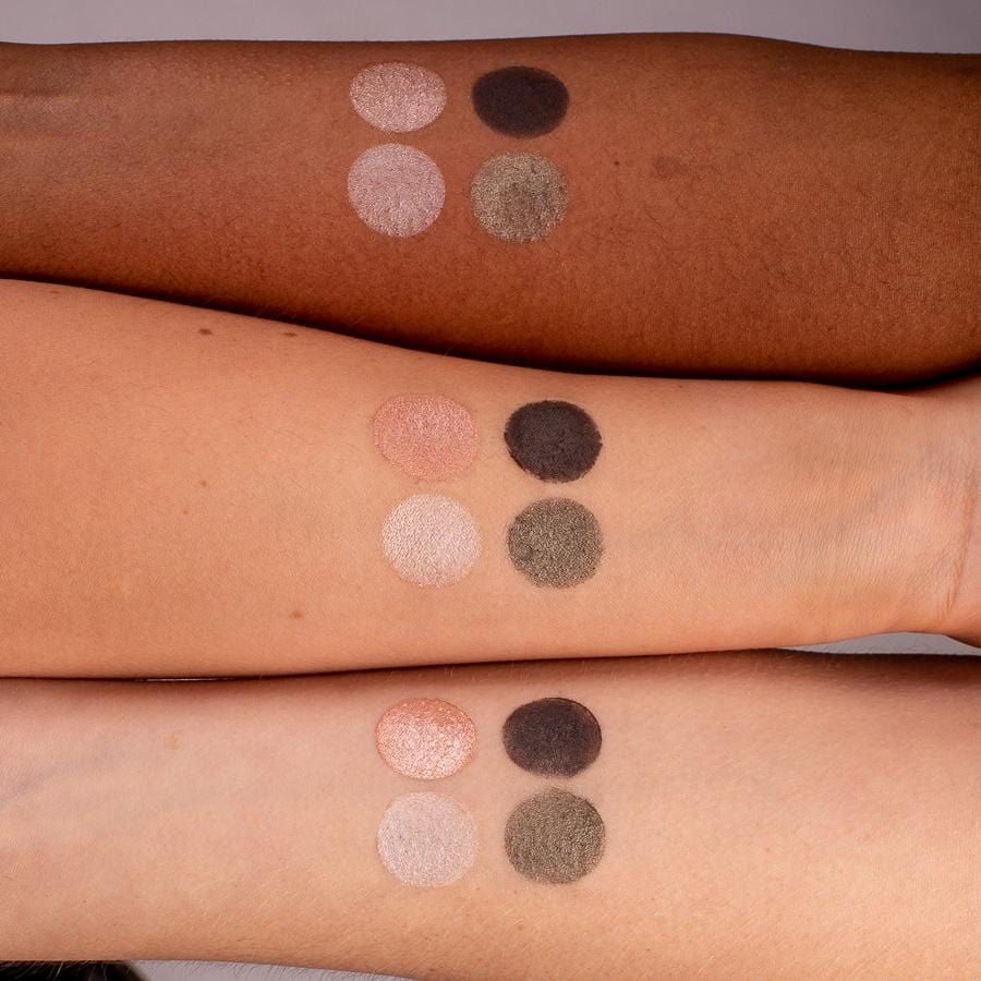 Arme mit vier Farbmustern der GRN [GRÜN] Lidschatten-Palette. Farben: hell, rosa, grün, dunkelgrau. Mehrere Hauttöne.