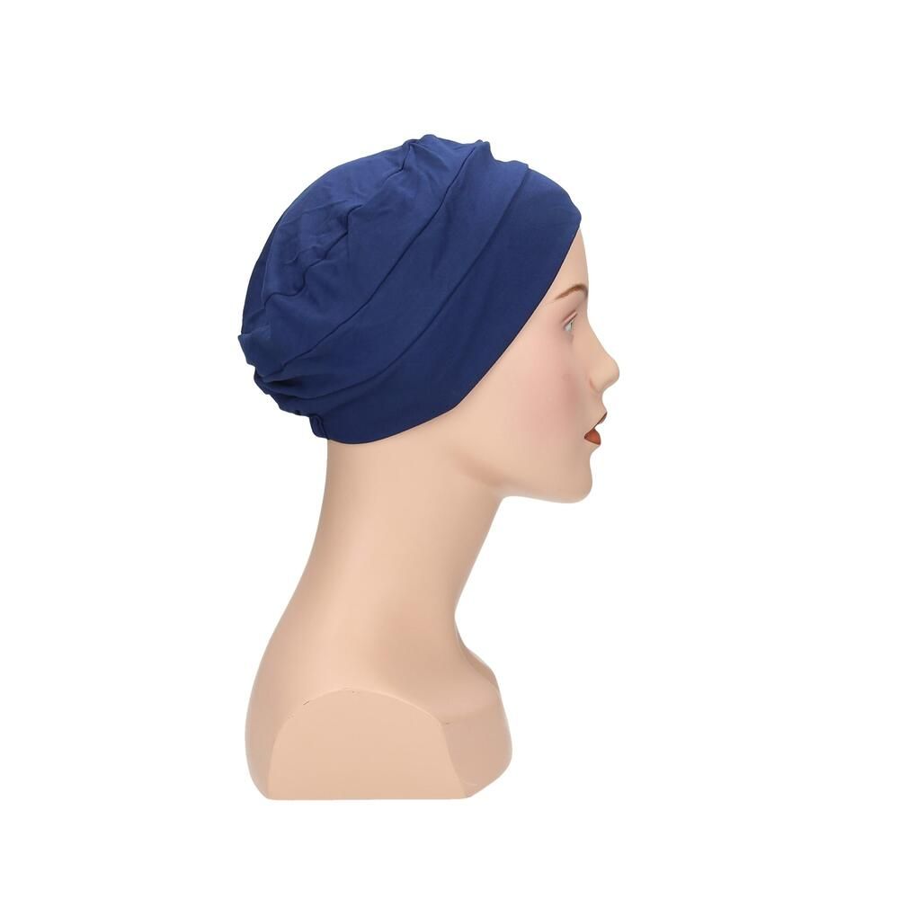 Blauer Turban auf einer Büste. Seitenansicht. Stoffhaube mit gerafftem Design.