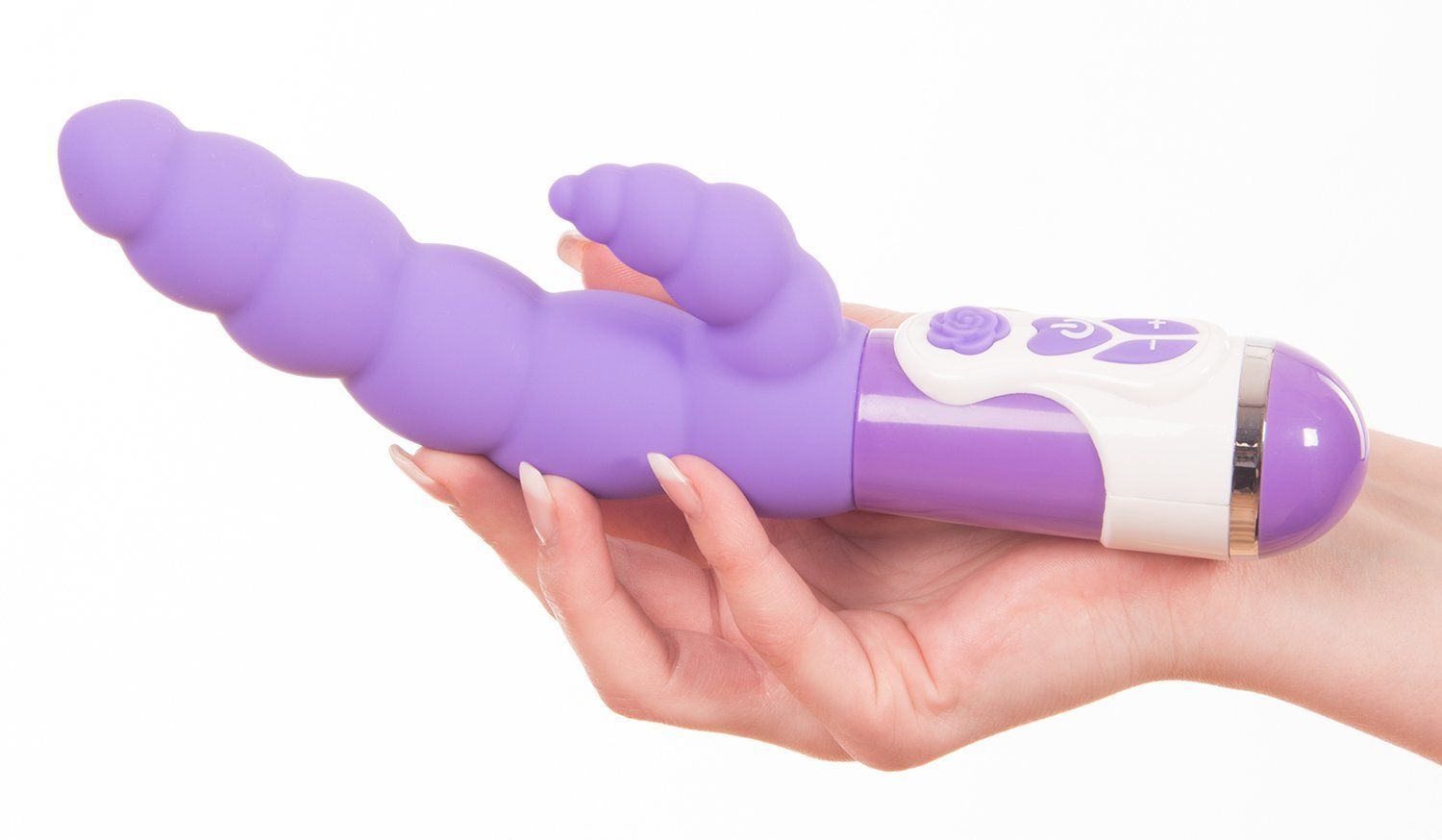 Lila Vibrator in einer Hand gehalten. Geriffelte Oberfläche, zusätzlicher Aufsatz, weißer Griff mit Knöpfen.
