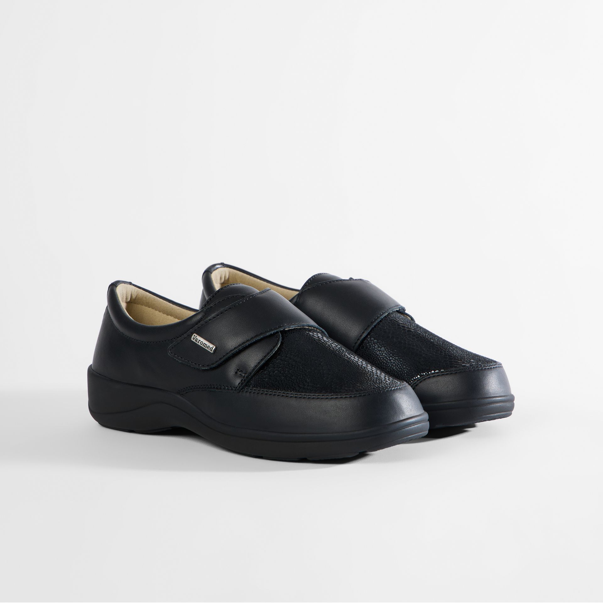 Schwarze Damenschuhe mit Klettverschluss. Sohle von unten gezeigt.