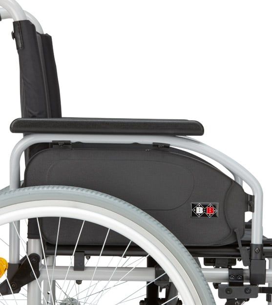 Detailansicht des Rollstuhls. Schwarze Seitenverkleidung mit Logo. Grauer Rahmen, schwarzer Sitz und Rad.