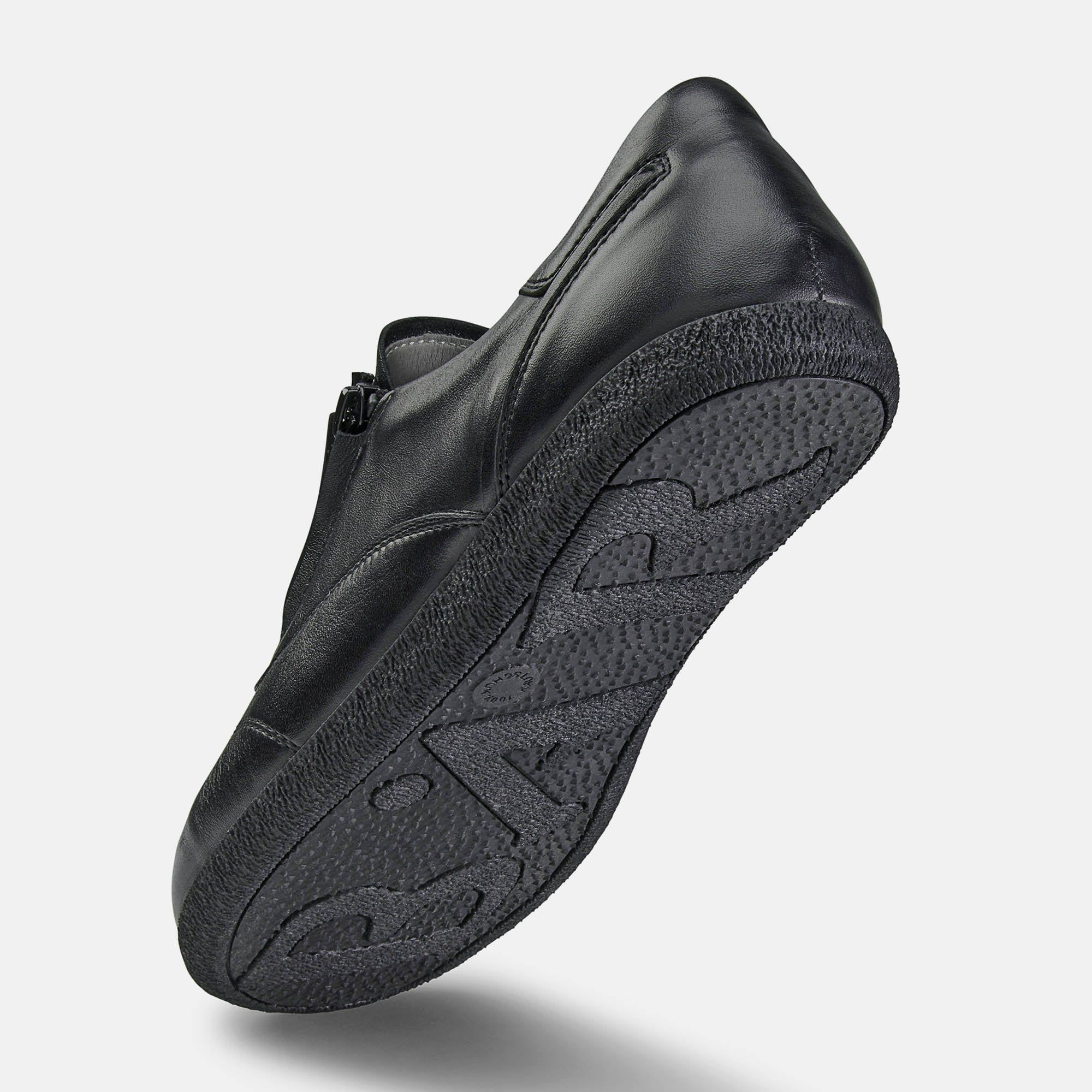 Schwarzer Schuh, Unterseite sichtbar. Profilsohle. Leder. Breite Passform. Schuh schräg von unten.