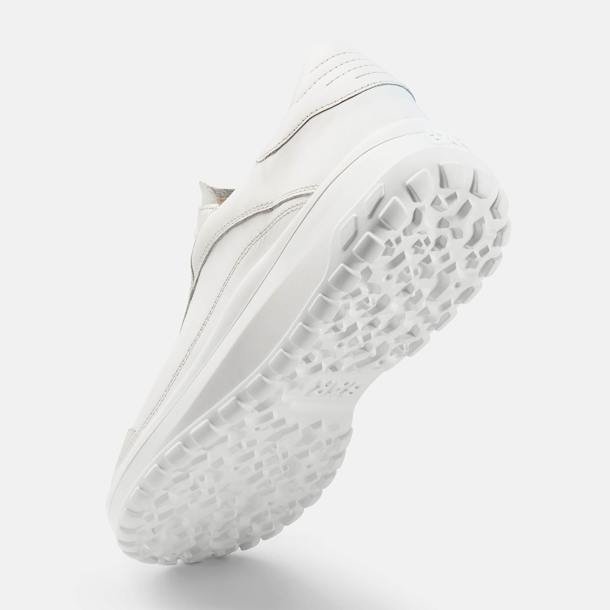 Weiße Schuhsohle von unten. Grobes Profil. Blick von unten nach oben. Abgerundete Form. Weißes Obermaterial.