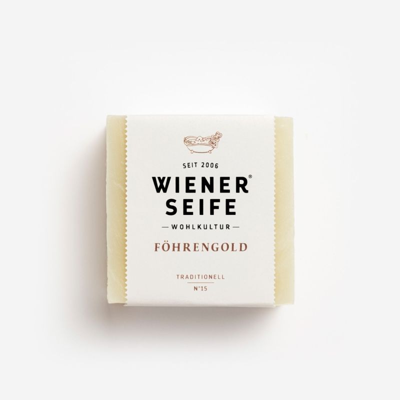 Seife mit Papierbanderole. Aufschrift: Wiener Seife, Föhrengold, N°15. Beige Seife, quadratisch.