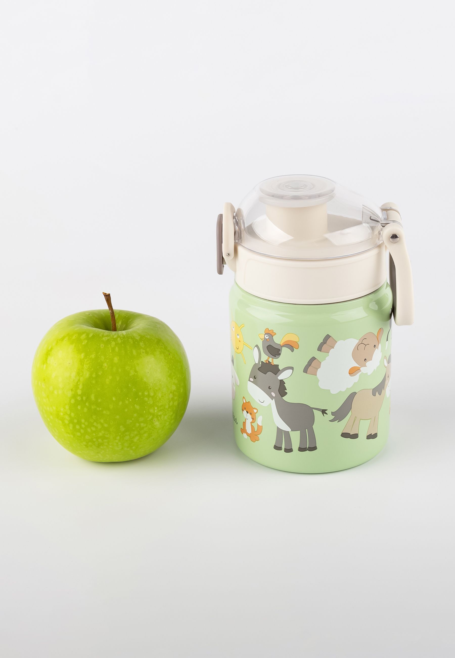 Grüne Edelstahl-Trinkflasche mit Bauernhof-Motiven neben einem grünen Apfel.