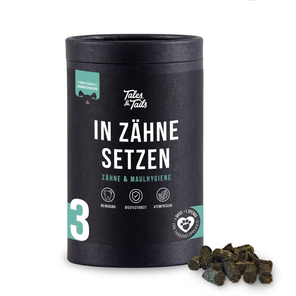 Schwarze Dose mit Produktnamen 'In Zähne setzen'. Grünliche Hundesnacks daneben. Logo 'Tales & Tails'.