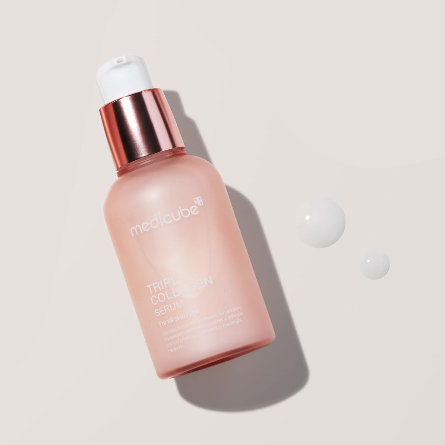 Rosa Serumflasche mit weißem Pumpkopf. Aufschrift: Triple Collagen Serum. Daneben Tropfen.