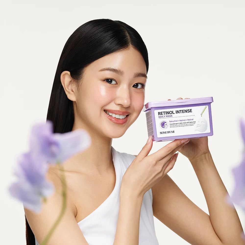 Eine lilafarbene Box mit der Aufschrift RETINOL INTENSE DAILY MASK. Der Deckel ist geöffnet, Masken sind sichtbar.