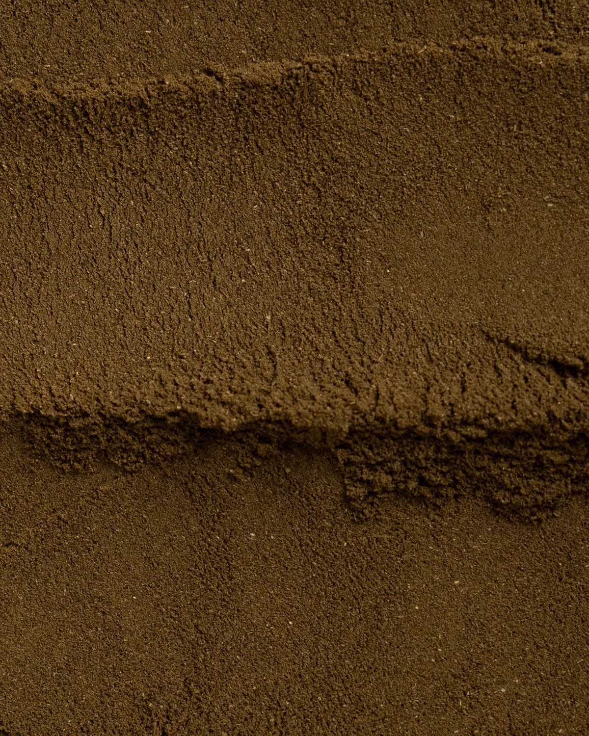 Nahaufnahme von braunem Pulver. Horizontale Linien. Textur sichtbar.